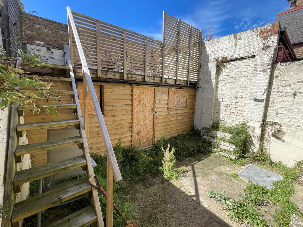 Lot: 144 - END-TERRACE PROPERTY ARRANGED AS THREE-BEDROOM HOUSE - Garden with timber outbuilding